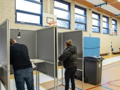 Twee kiezers stemmen in stemlokaal