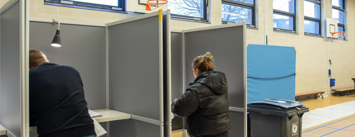 Twee kiezers stemmen in stemlokaal